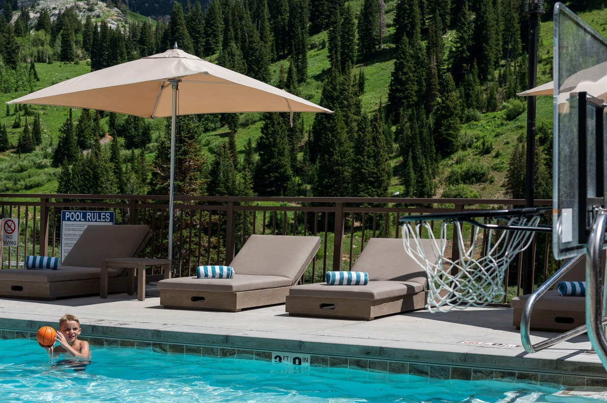 Young boy playing basketball in the outdoor pool