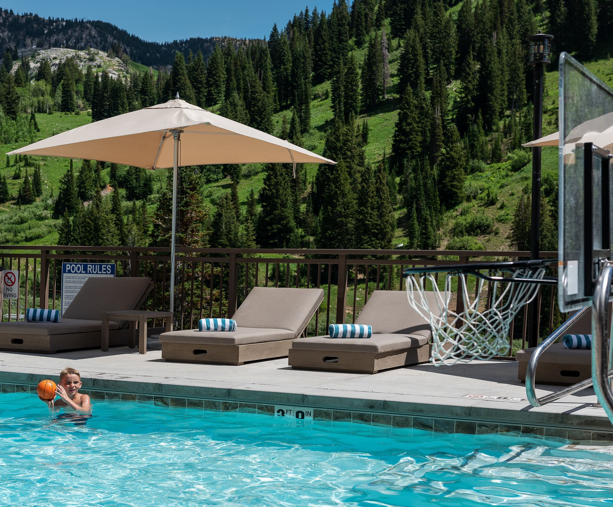 Young boy playing basketball in the outdoor pool