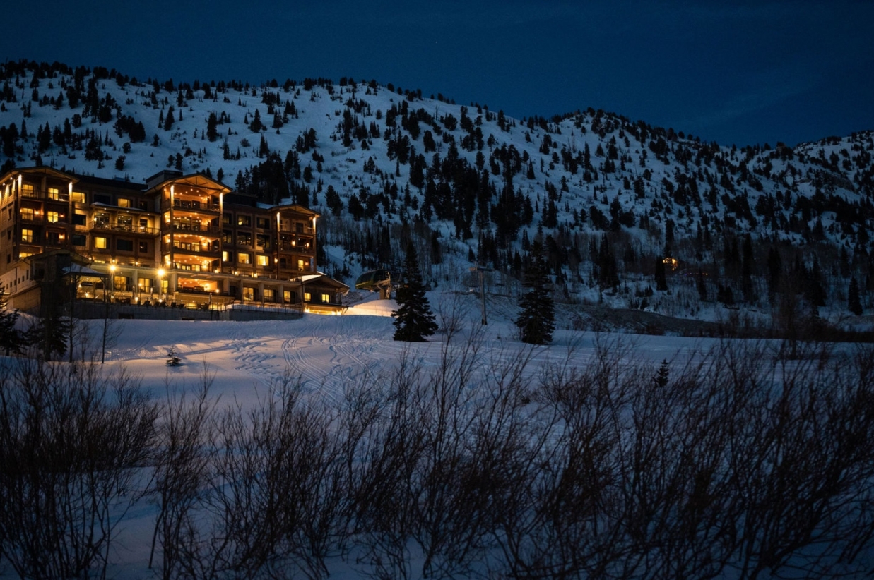 Snowpine Lodge at dusk with snow in the background