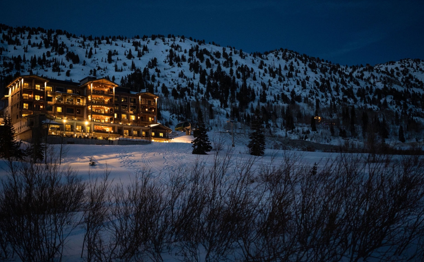 Snowpine Lodge at dusk with snow in the background