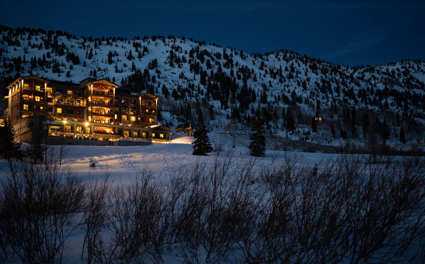 Snowpine Lodge at dusk with snow in the background