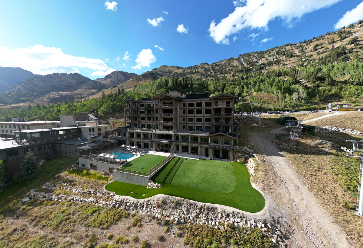 Aerial view of the lodge featuring a green lawn in summer.