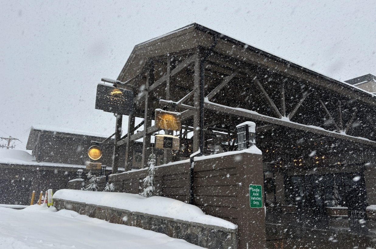 Snow-covered wooden structure at the base of a ski area.