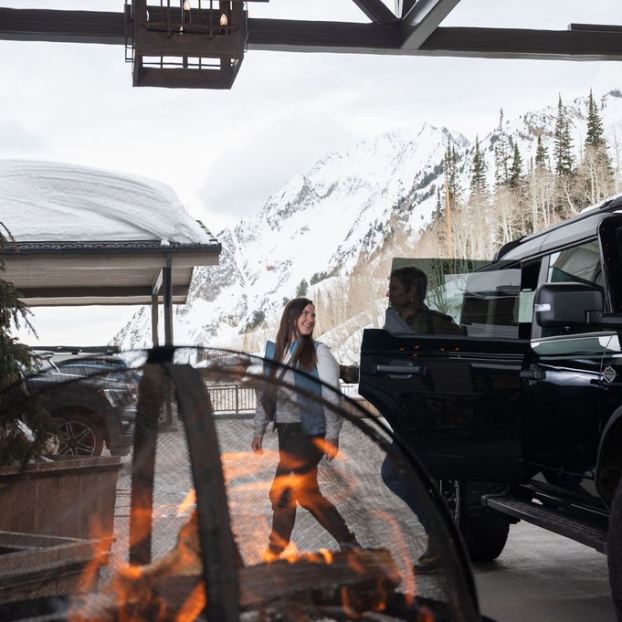 Couple standing next to a Jeep parked outside the lodge entrance.