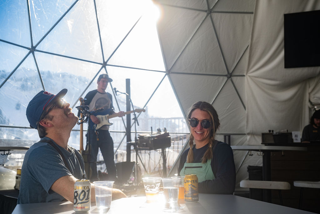 Couple socializing inside a sunlit transparent dome.