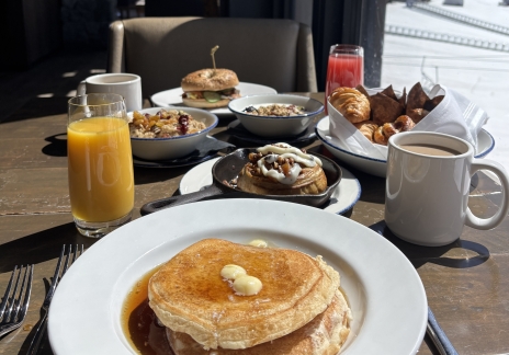 Close-up of a stack of pancakes with syrup and butter.