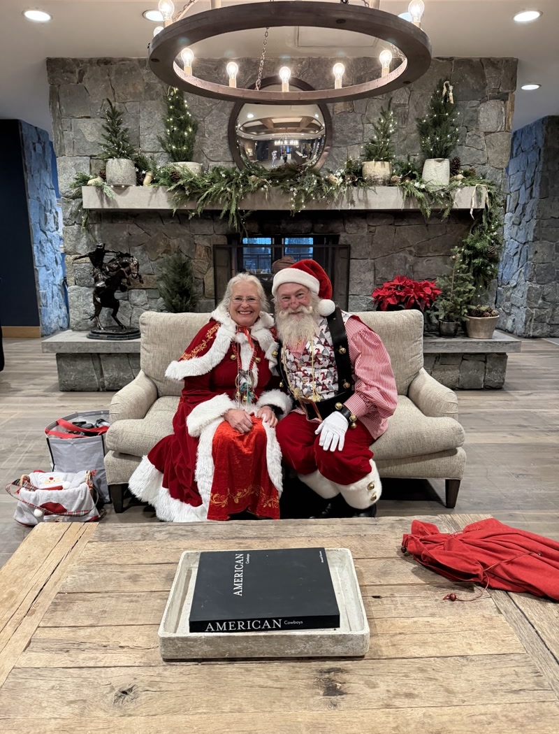 Santa and Mrs. Claus sitting in front of the fireplace at Snowpine Lodge